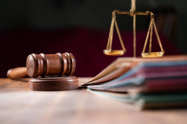 Maillet posé sur un bureau avec des documents, représentant les risques juridiques de ne pas être couvert par les assurances indispensables pour les freelances